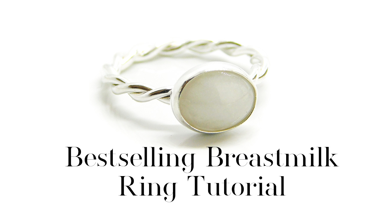 Bestselling Breastmilk Ring Tutorial, 10x8mm oval cabochon stone with breastmilk and no sparkles, set in a rubover bezel cup on a handmade twisted band ring. Made in the UK by Nikki Kamminga breast milk jewellery